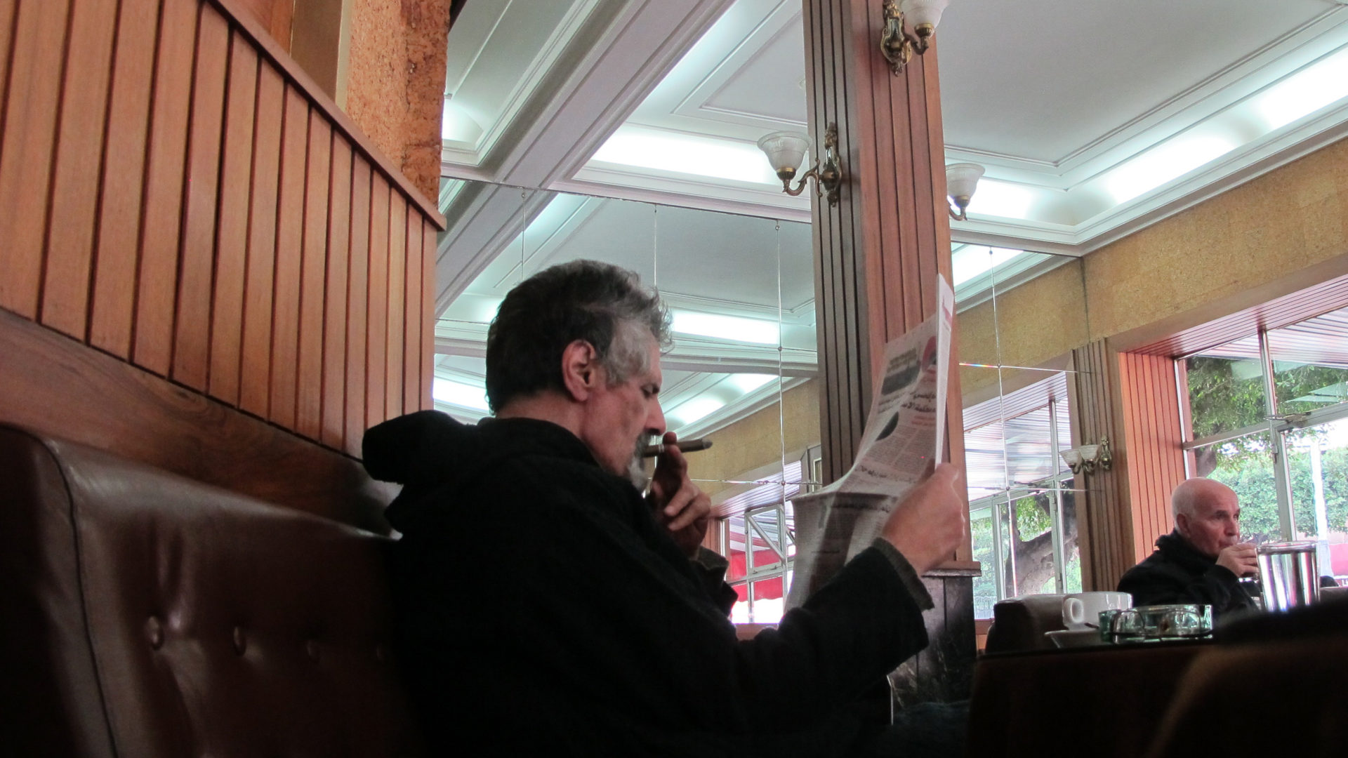 Reading paper with cigar in Cafe de Paris