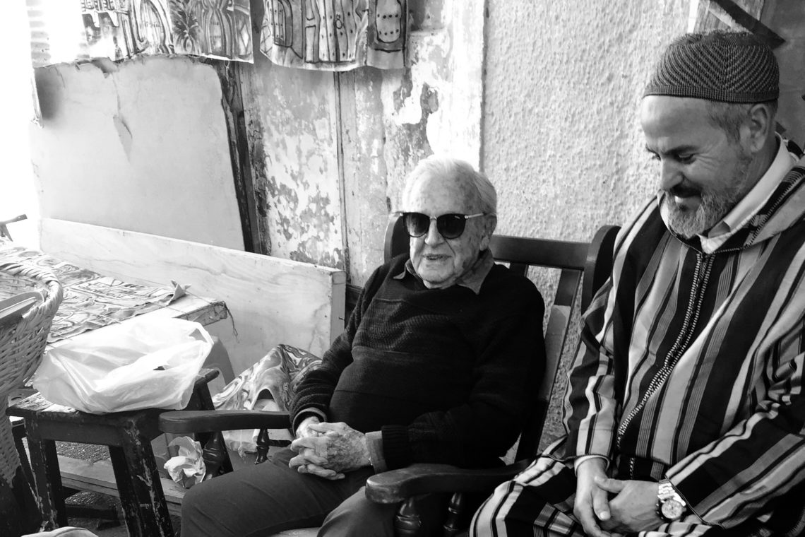 Sam Cohen (with glasses) getting a shoe shine next to a friend.