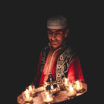 Bashir holding a tray of candles. Photograph by Will Rijnbout.