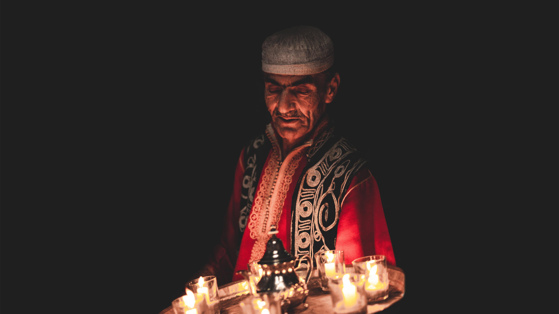 Bashir holding a tray of candles. Photograph by Will Rijnbout.