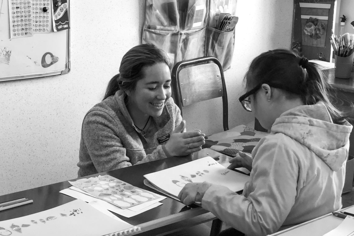 Shelby Clare and a student working on stickers